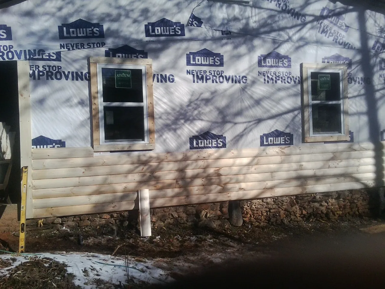 House wrap and new log siding going up on an exterior wall in Portland